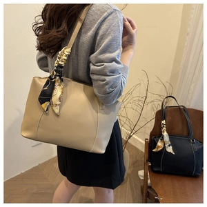 Detail of a beige tote bag with decorative silk scarf and contrast stitching for work