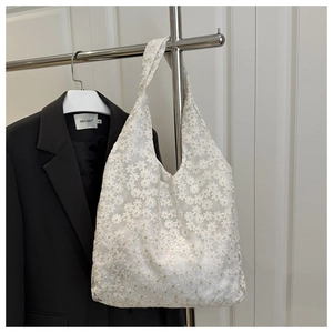 Close-up of white floral lace tote bag featuring intricate embroidery and hollow-out texture