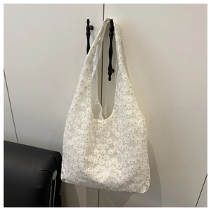 Detailed close-up of white mesh tote bag with 3D floral daisy embroidery texture