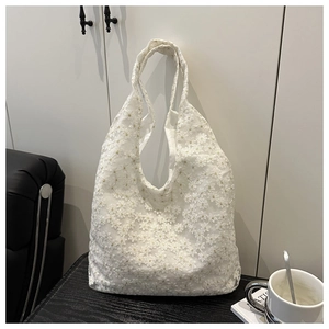 Close-up of white floral lace crochet texture and detail on the mesh tote bag