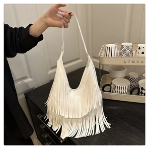 Detailaufnahme der weißen Hobo-Tasche mit langen Fransen in minimalistischem Interieur
