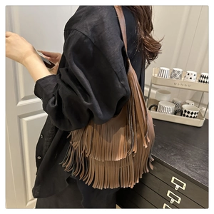 Detalle del bolso tote de cuero marrón con elegantes flecos decorativos de doble capa