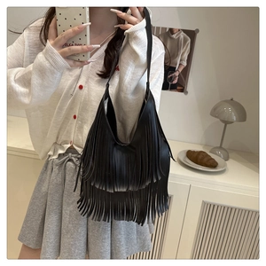 Detail der schwarzen Hobo-Tasche mit langen Fransen und hochwertiger Lederstruktur