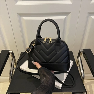 Bolso tipo concha negro acolchado en V con herrajes dorados para uso manual o cruzado