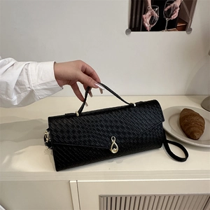 Minimalist black embossed leather crossbody handbag with stylish gold treble clef clasp