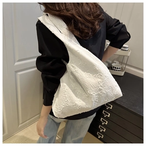 Détail de la broderie florale blanche sur un grand sac fourre-tout en coton et lin