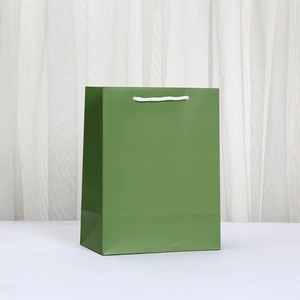 Minimalist deep green paper shopping bag with white rope handles for gift packaging