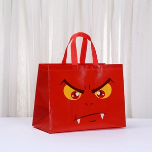 Detail of red non-woven gift bag with a yellow-eyed cartoon monster print