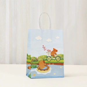 Detail of light blue paper gift bag featuring cute Capybara illustrations and white handles