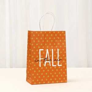 Orange Thanksgiving paper gift bag with FALL in the air typography and white polka dots