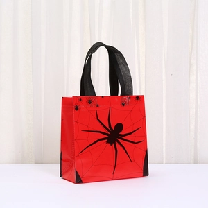 Close-up of red non-woven Halloween gift bag with black spider and web print design
