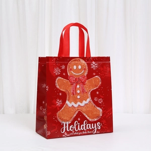 Close-up of red non-woven Christmas gift bag with gingerbread man print and snowflakes