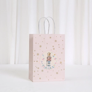 Pink Christmas kraft gift bag with Nutcracker illustration and white paper rope handles