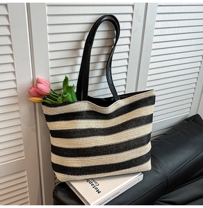 Detail of black and beige striped woven tote bag with long leather handles and tulips