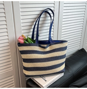 Detailed close-up of blue and white striped woven tote bag with tulips and glossy handles
