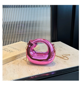 Detail of a bright pink metallic mini bag with mirror finish and gold chain strap