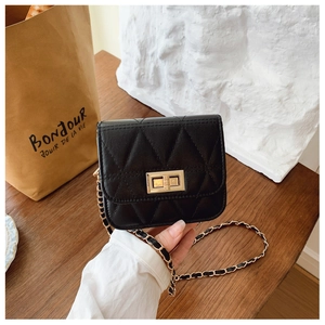 Détail d'un mini sac matelassé noir avec fermoir doré et bandoulière en chaîne dorée
