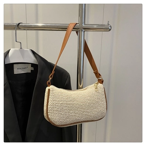 Détail du sac bandoulière tissé avec garniture en cuir marron et fermeture éclair dorée