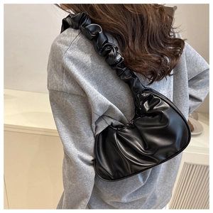 Dettaglio di una borsa a nuvola nera increspata con tracolla arricciata su modella
