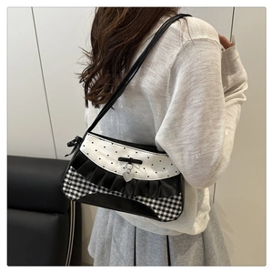 Close-up of lace bow shoulder bag featuring heart polka dots and checkered patterns