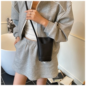 Detail of black lychee grain mini crossbody bag with functional front slip pocket