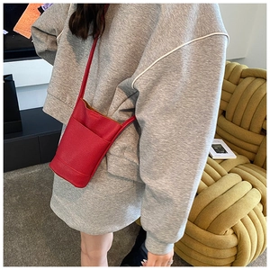 Texture dettagliata della pelle PU rossa con motivo litchi su una mini borsa porta cellulare