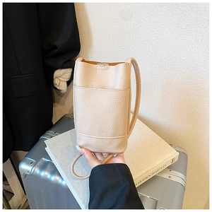 Detail of light beige litchi grain leather crossbody phone bag with slim shoulder strap