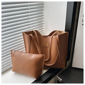 Brown leather tote bag set with matching pouch and Fashion logo in natural sunlight