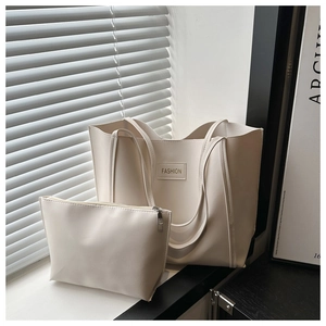 Detail of off-white large tote bag and matching zipper pouch in soft sunlight setting