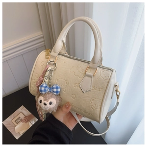 Detail of cream boston bag with 3D bear embossment and plush charm accessory