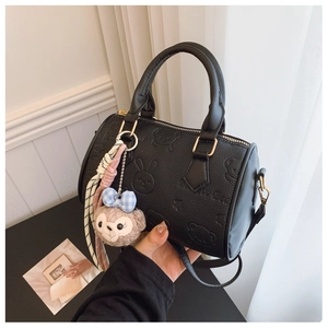 Detail of black pebbled faux leather handbag with embossed cartoon bear and rabbit patterns