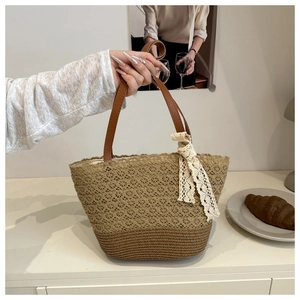 Detailed weave pattern and leather handles of this beach tote bag with a lace bow