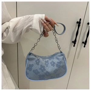 Detail of light blue floral embossed shoulder bag with silver chain strap and leather belt