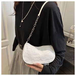 Detailed shot of white floral jacquard shoulder bag with silver chain strap on model