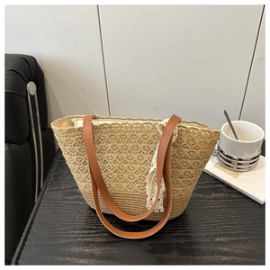 Detail of beige woven straw tote with delicate lace trim and brown leather shoulder strap