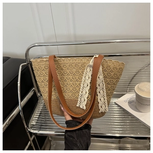 Detail of straw tote bag with beige lace overlay and elegant ribbon bow decoration
