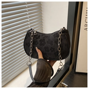 Detail of black floral jacquard hobo bag with silver chain and leather strap