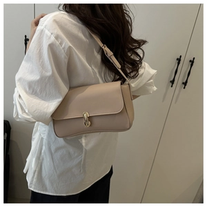 Detail of beige faux leather shoulder bag featuring a sleek gold rectangular buckle