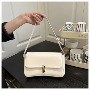 Close-up of minimalist cream white shoulder bag with gold metal lock and leather texture