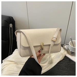 Close-up of stylish cream leather handbag featuring a golden metallic bar twist lock