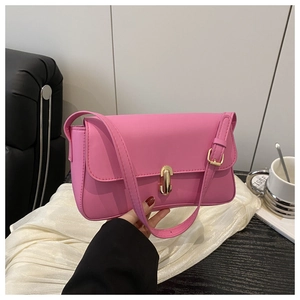 Pink minimalist shoulder bag with capsule-shaped gold buckle and adjustable strap