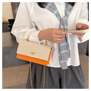 Détail du sac bandoulière en paille tissée et cuir orange avec fermoir doré rond