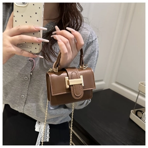 Détail du mini sac carré marron avec bandoulière en chaîne dorée et boucle métal