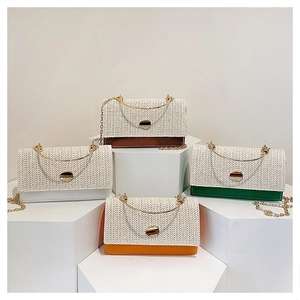 Detail view of woven straw shoulder bags in four colors with gold chain straps