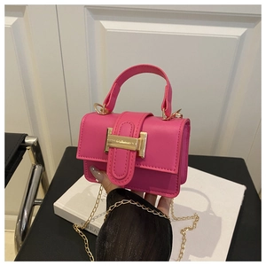 Detail of rose red mini square bag with golden buckle and sleek leather texture
