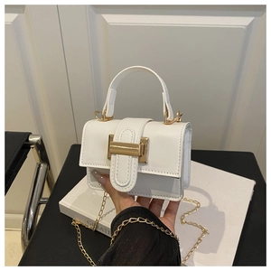 Close-up of white mini handbag with elegant gold H-shaped buckle and chain strap detail