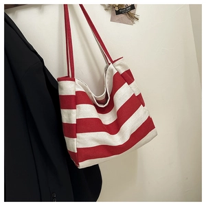 Detail of red and white striped canvas tote bag showing textured fabric and red strap
