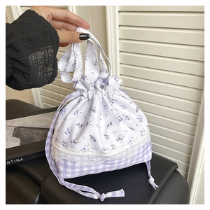 Detail of floral and plaid patchwork handbag with lace trim and drawstring closure