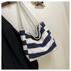 Detail of striped canvas tote bag showing thick fabric texture and white rope handle