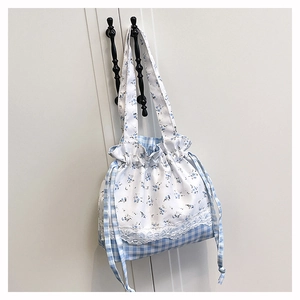 Detail of floral and plaid patchwork shoulder bag with delicate white lace trim